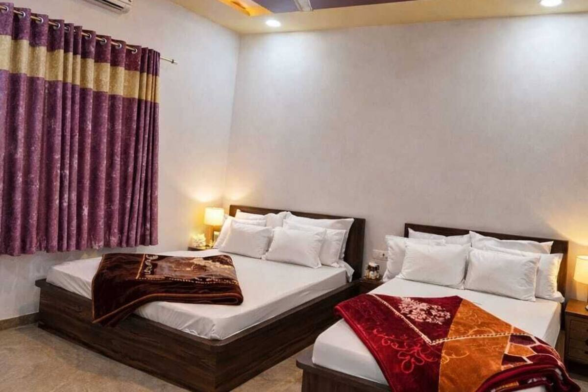 A hotel room with two beds, a ceiling fan, and a modern design.