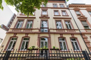 A multi-story hotel with a classic architectural design, featuring a prominent 'West' sign, multiple windows, and a decorative iron fence.