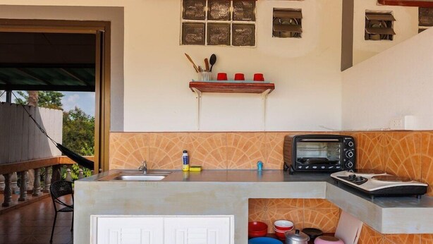 Une cuisine équipée d’un four encastré, d’un évier et d’un plan de travail sur lequel se trouve un grille-pain.