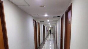 A long, narrow hallway with doors on both sides, leading to individual rooms. - Japlen Room (South Tangerang)