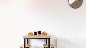 Ein kleiner Tisch mit zwei Hocker, zwei Tassen und zwei Croissants.