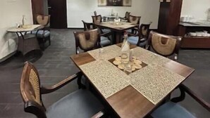 Un comedor con candelabro, mesas y sillas de madera.