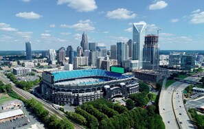 A stadium with a large blue roof and a parking lot.