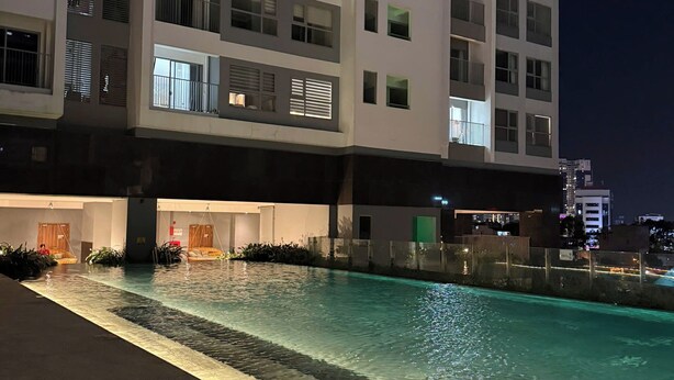 Un hotel moderno con piscina, varias plantas y balcones.
