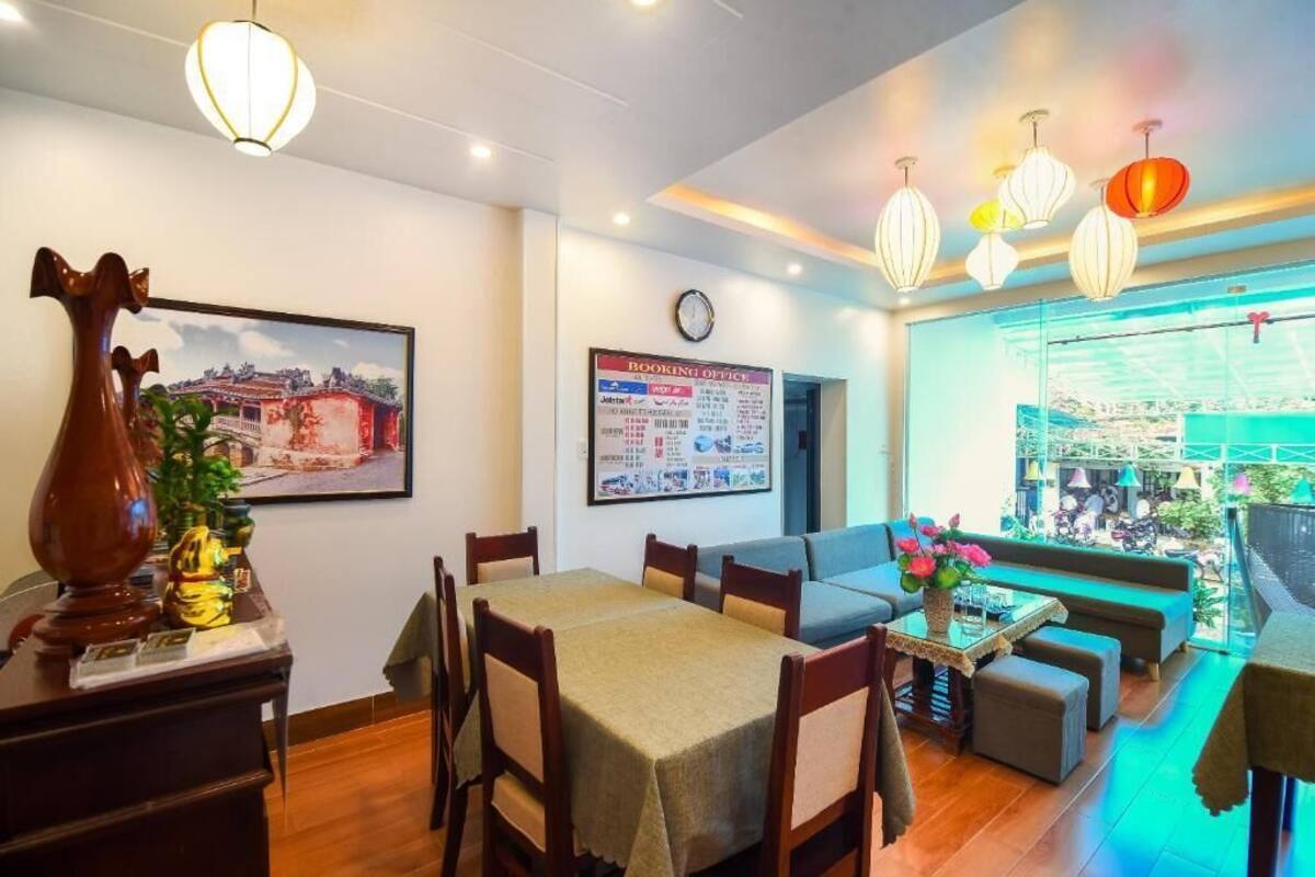 A hotel lobby with a dining area, a booking office, and a view of the outside.