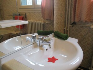 A bathroom with a white sink, a mirror, a towel rack, and a window. - La Source - Appartment & terrace - 90m2 - France, Auvergne Volcanoes Park (Orcival)