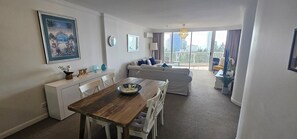 Una sala moderna con comedor, sofá y balcón con vistas.