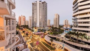 Un hotel urbano moderno con varios pisos, zonas de estar al aire libre y un patio central.