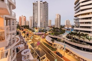 Un hotel urbano moderno con varios pisos, zonas de estar al aire libre y un patio central.