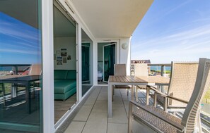 A balcony with a table and chairs, a sofa, and a view of the sea. - Stunning apartment in Kappeln with sauna (Kappeln)
