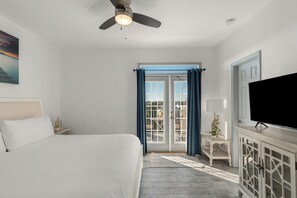 A bedroom with a bed, a ceiling fan, a television, a cabinet, and a view of the outside through a glass door. - Pool Access + Tennis Court + Balcony Dining + Near Beach | Emerald Breeze (Destin)