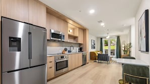 Eine moderne Küche mit Edelstahlgeräten, Holzschränken und einem Essbereich mit Tisch und Stühlen.