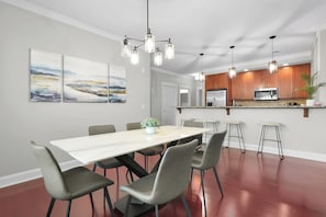 A modern kitchen with wooden cabinets, a stainless steel refrigerator, and a microwave. - Historic District 3BDR Getaway | The Juliette (Savannah)