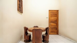 Ein Essbereich mit Holztisch und -stühlen, einer Holztür und einem gefliesten Boden.