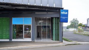Ein modernes Gebäude mit einem blauen Schild, auf dem „rehat“ und „Siliwangi Guesthouse Syariah“ steht.