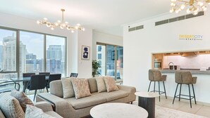 A modern living room with a sofa, coffee table, and bar stools. - Fully Furnished 2 Bed in Dubai Marina. (Dubai)