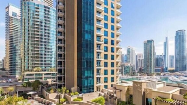 A high-rise hotel with a modern glass facade, a rooftop pool, and a landscaped courtyard. - Fully Furnished 2 Bed in Dubai Marina. (Dubai)