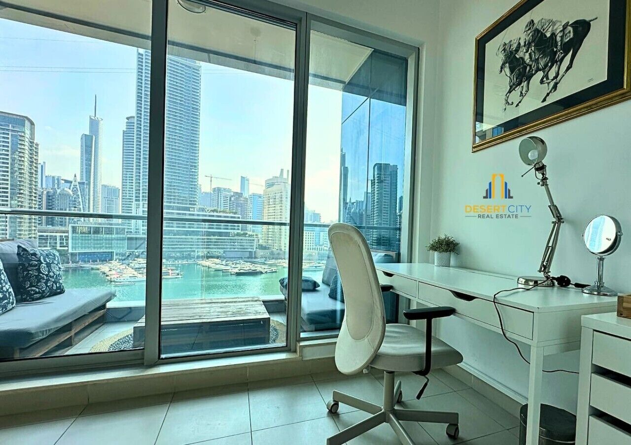 Ein modernes Büro mit einem großen Fenster und Blick auf eine Skyline sowie Wasser.