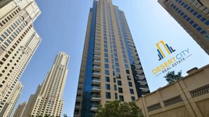 A tall building with a modern design, surrounded by other high-rise buildings. - Fully Furnished 2 Bed in Dubai Marina. (Dubai)