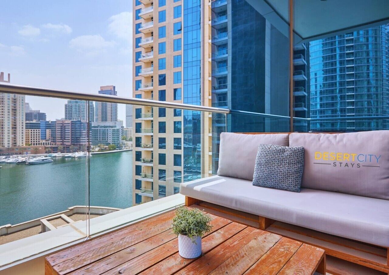 Ein Balkon mit einer Couch, einem kleinen Tisch und einem Blumentopf.