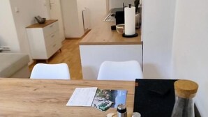 Un área de comedor con una mesa de madera, un menú, saleros y pimenteros, y un candelabro.