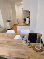 Un área de comedor con una mesa de madera, un menú, saleros y pimenteros, y un candelabro.
