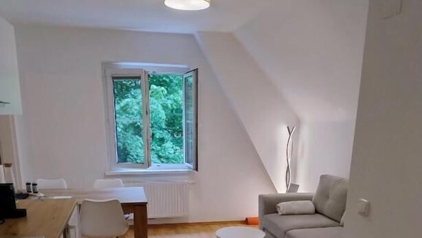 Un apartamento moderno, bien iluminado, con cocina, comedor y sala de estar.
