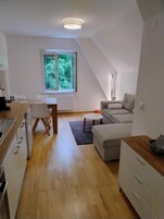 Un apartamento moderno, bien iluminado, con cocina, comedor y sala de estar.