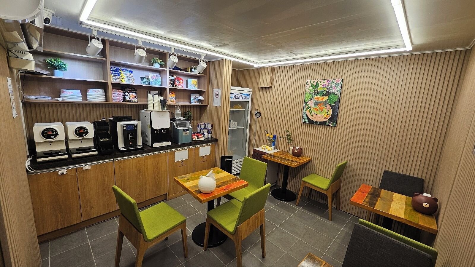A café with a counter, coffee machines, and seating area with chairs and tables.