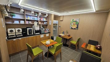 A café with a counter, coffee machines, and seating area with chairs and tables.