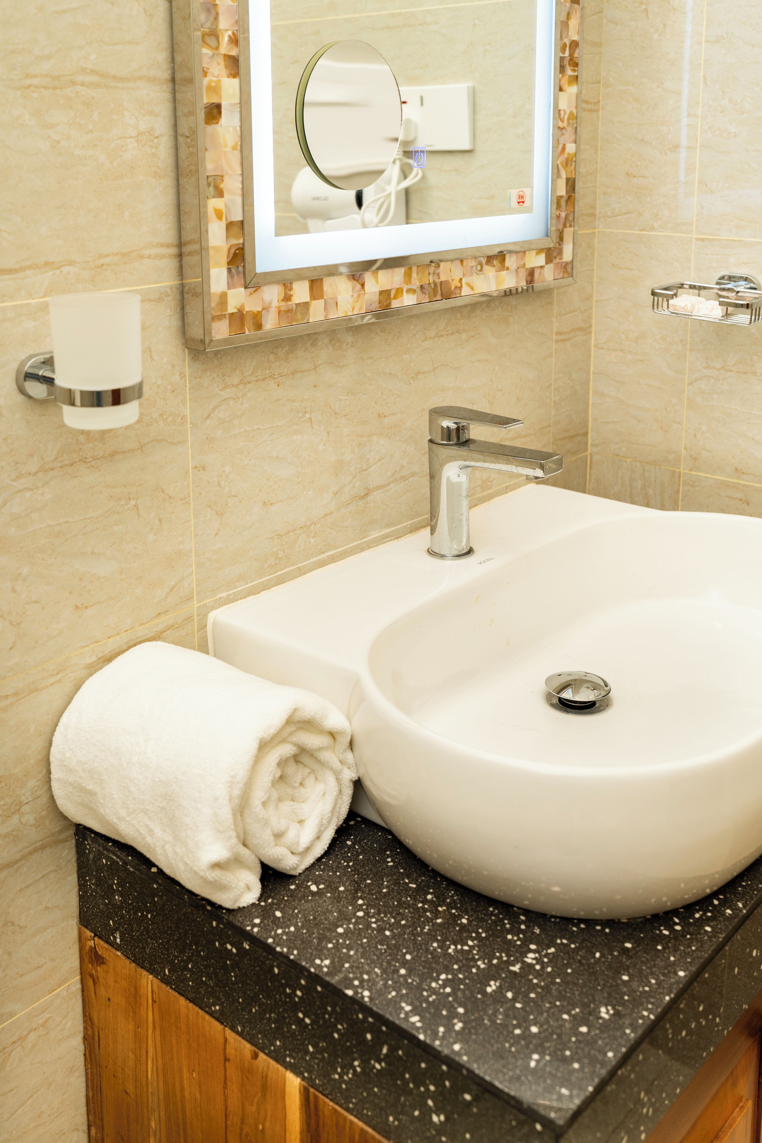 A bathroom with a white sink, a mirror, and a towel on the counter.