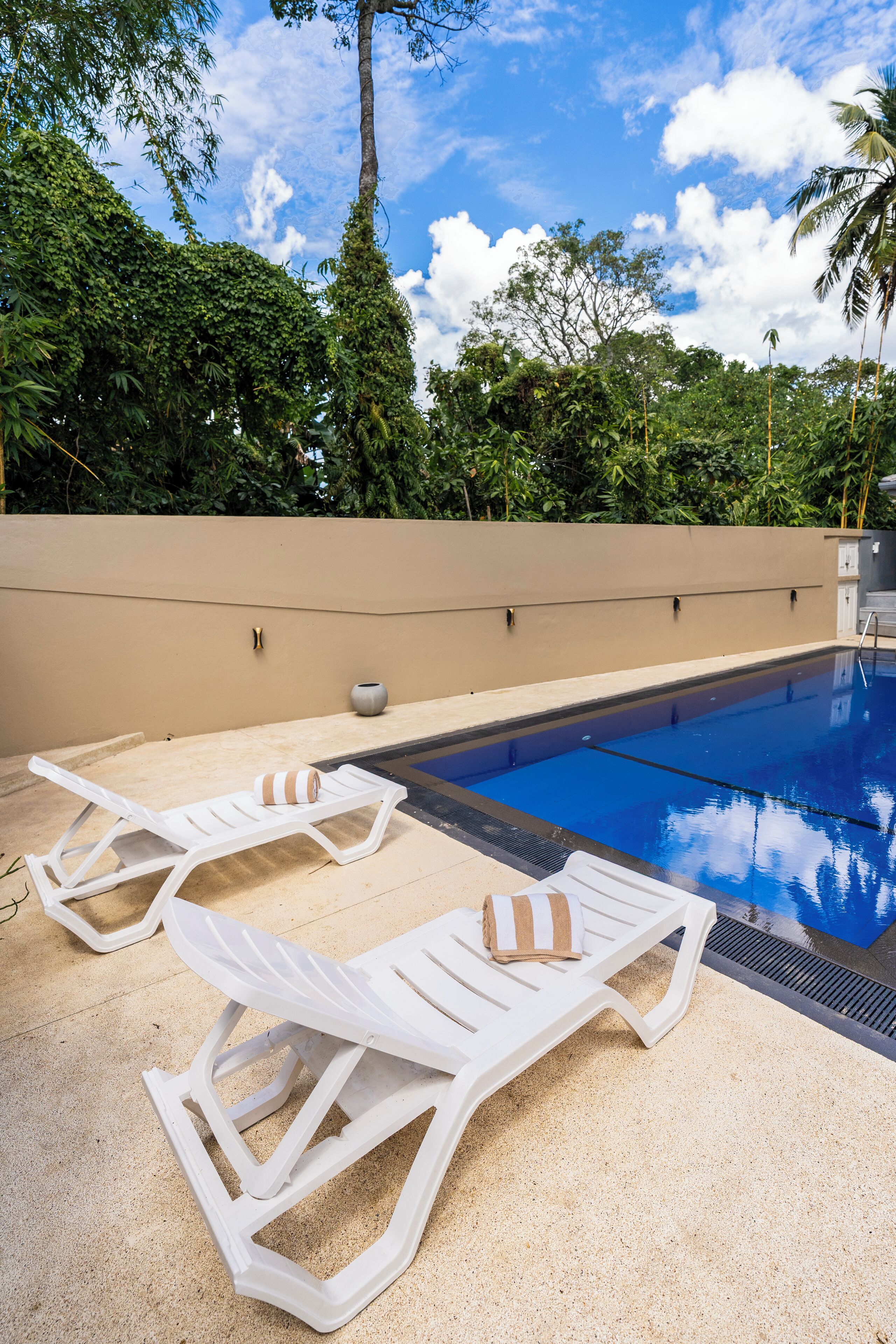 Una piscina al aire libre, sillones reclinables de piscina