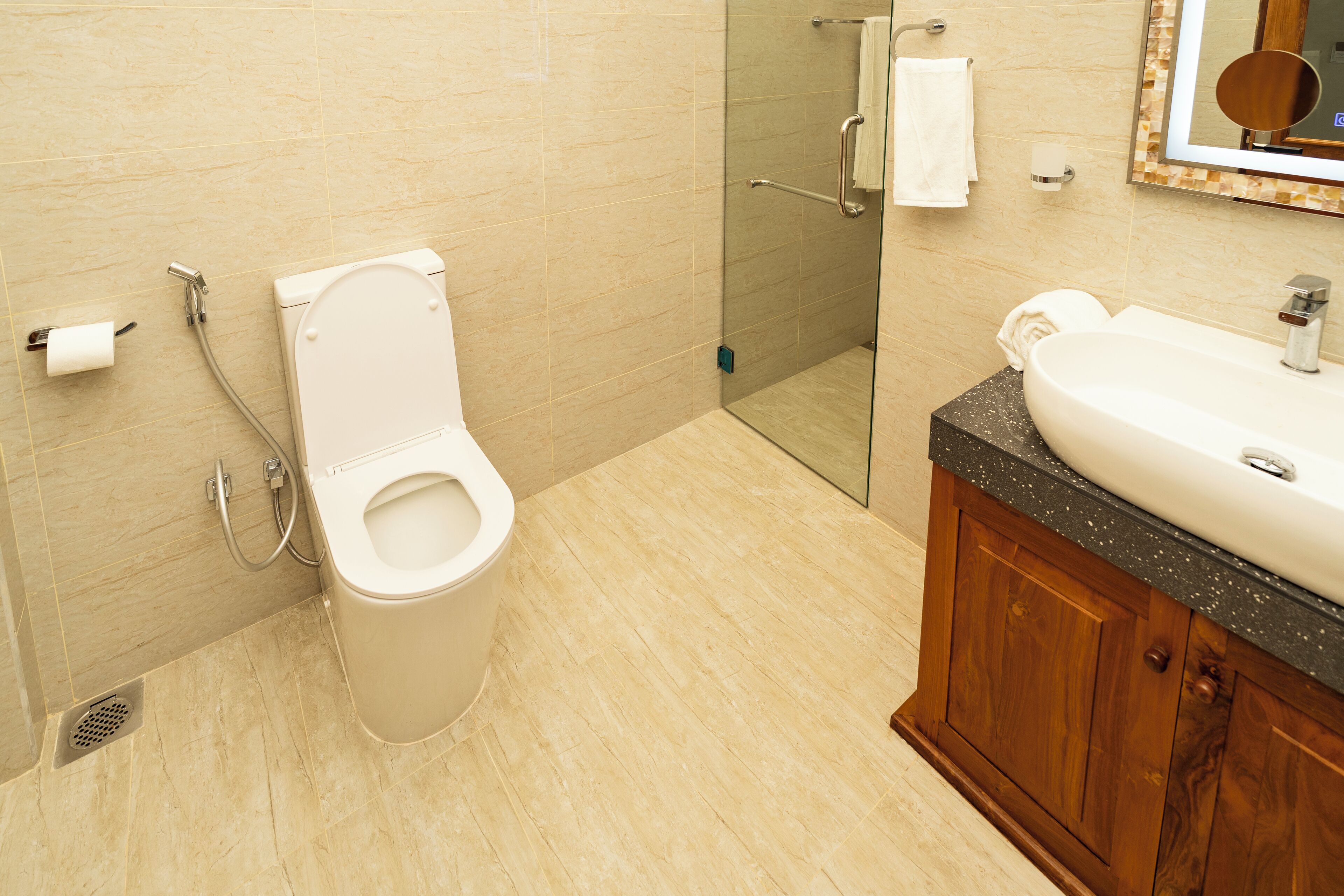 A modern bathroom with a toilet, shower, and sink.