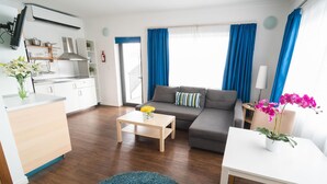 A compact living space with a kitchenette, a sofa, a dining table, and a small coffee table. - Park Lane (St. Paul's Bay)