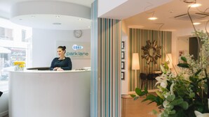 A reception desk with a clock and a sign for 'park lane apartment hotel'. - Park Lane (St. Paul's Bay)