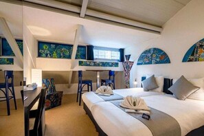 A hotel room with a bed, two chairs, a desk, and artwork on the walls. - H2otel Rotterdam (Rotterdam)