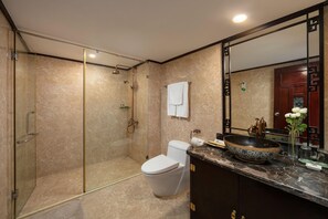 A modern bathroom with a glass-enclosed shower, a white toilet, and a vanity with a large mirror and a decorative bowl. - Hong Ngoc Dynastie Hotel (Hanoi)