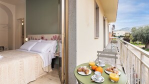 A bedroom with a bed and a balcony with breakfast setup. - Bed&Breakfast Anna's Dream a 500m dal centro storico e 1,2 km dal mare di Avola (Avola)