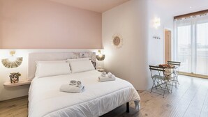 A bedroom with a bed, bedside tables, a desk with chairs, and a large window. - Bed&Breakfast Anna's Dream a 500m dal centro storico e 1,2 km dal mare di Avola (Avola)
