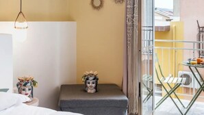 A hotel room with a bed, a small table with a decorative item, a hanging light fixture, and a view of the outside balcony. - Bed&Breakfast Anna's Dream a 500m dal centro storico e 1,2 km dal mare di Avola (Avola)