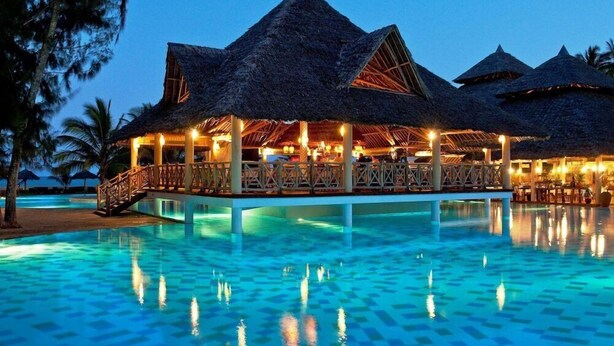 Ein Resort mit Bungalows über dem Wasser, einem Pool und einem Essbereich.