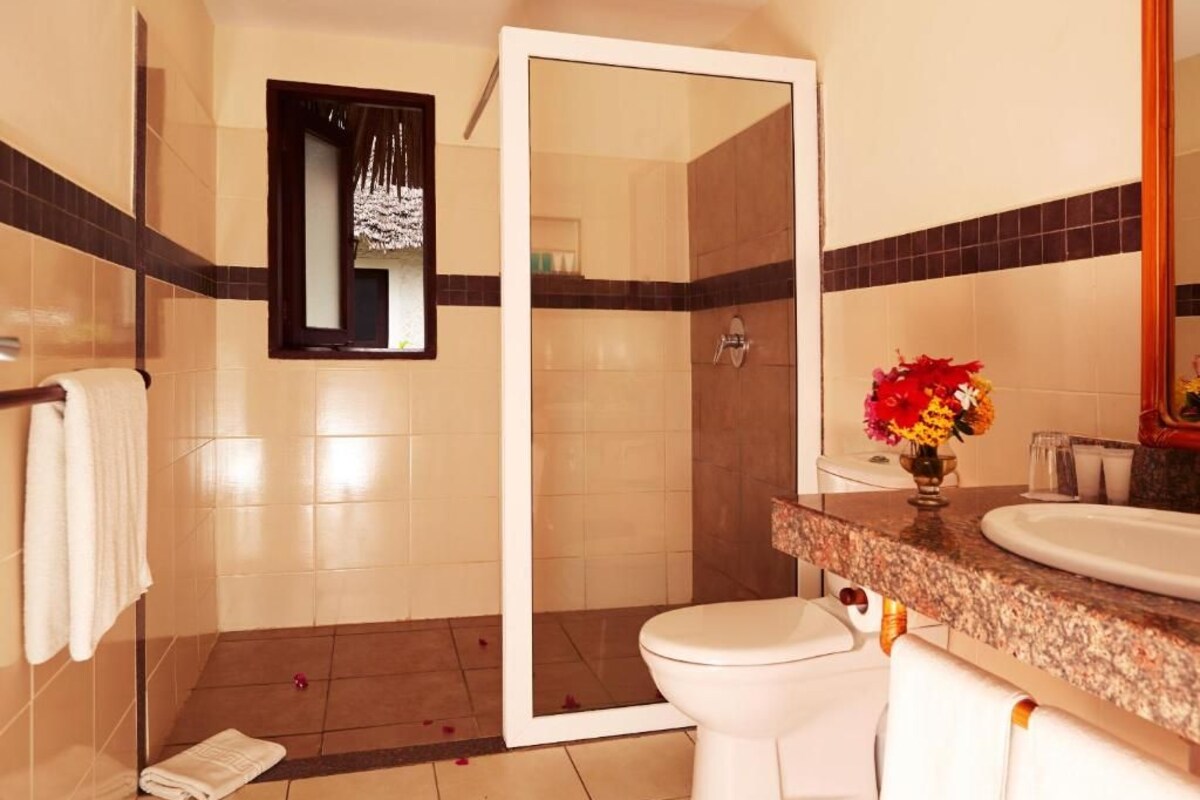 A bathroom with a shower, toilet, and sink.