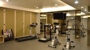 Un gimnasio equipado con cintas de correr, elípticas y una bicicleta estática.