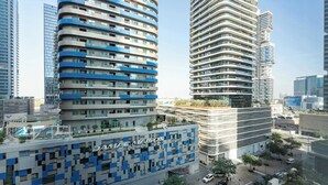 Un hotel moderno con una facciata unica caratterizzata da pannelli blu e bianchi, circondato da grattacieli.