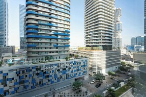Ein modernes Hotel mit einer markanten Fassade aus blauen und weißen Paneelen, umgeben von Hochhäusern.