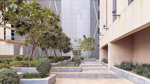 Un edificio moderno con un cortile centrale, dotato di fioriere geometriche e un percorso piastrellato.