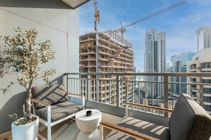 Ein Balkon mit einem Blumentopf, einer Couch und einem kleinen Tisch.