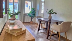 En matplats med ett träbord, två stolar och krukväxter.