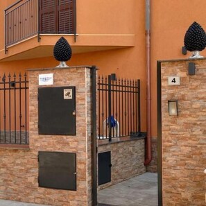 A building with a stone facade, a metal gate, and a number '4' sign. - Aphrodite's apartment at Aspra (BAGHERIA)