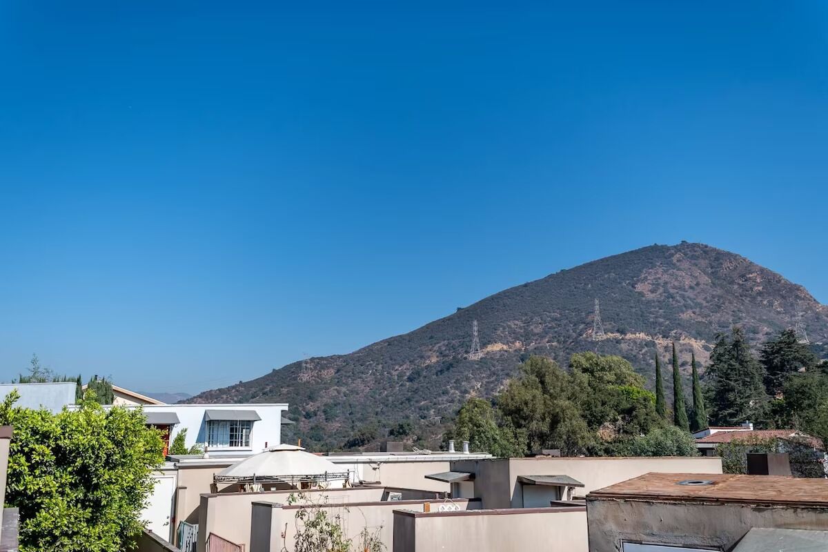 A residential area with modern buildings and a mountain in the background.